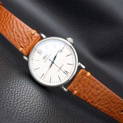 Side-stitched strap in brown vegetable-tanned leather with orange stitching
