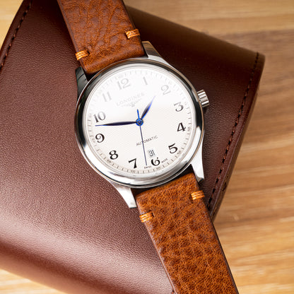Side-stitched strap in brown vegetable-tanned leather with orange stitching
