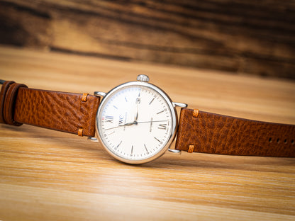 Side-stitched strap in brown vegetable-tanned leather with orange stitching